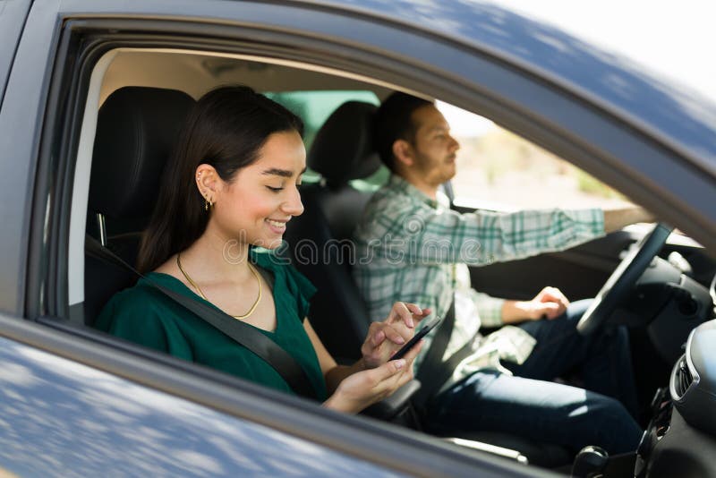 Ett lyckligt par som använder gps på telefonen under körning royaltyfri fotografi