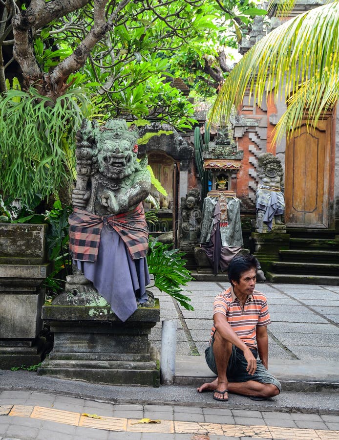 Ett mansammanträde på gatan i Bali, Indonesien royaltyfri bild Ett mansammanträde på gatan i Bali, Indonesien royaltyfri bild