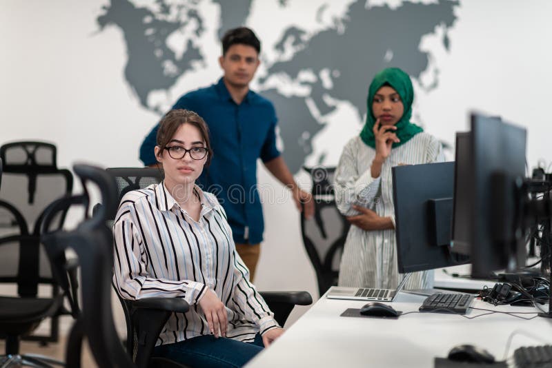Ett multietniskt startteam, arabisk kvinna med hijab på möte i det moderna, öppna planeringskontoret i inlandet arkivfoton