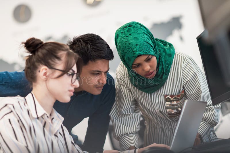 Ett multietniskt startteam, arabisk kvinna med hijab på möte i det moderna, öppna planeringskontoret i inlandet arkivbilder