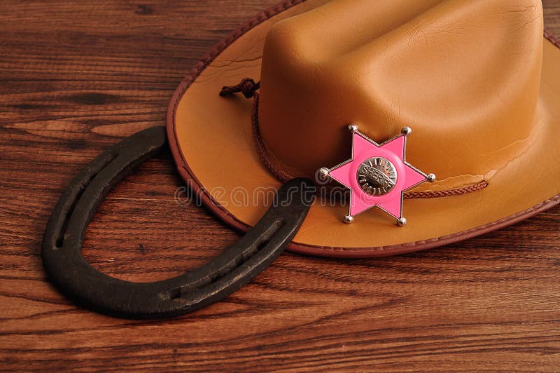 Ett sheriffemblem med en brun cowboyhatt och en hästsko royaltyfria foton Ett sheriffemblem med en brun cowboyhatt och en hästsko royaltyfria foton