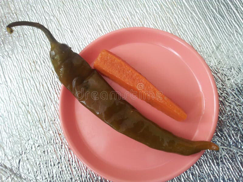 Ett slut upp peppar för siktsgräsplanchili med moroten tjänade som i en liten platta arkivbild Ett slut upp peppar för siktsgräsplanchili med moroten tjänade som i en liten platta arkivbild
