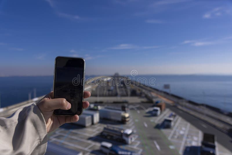 A traffic jam shooting by smartphone on the highway at Tokyo bay area in Chiba. High quality photo. Kisarazu district Chiba Japan 01.30.2024 Here is the highway parking called UMIHOTARU PA in Chiba. A traffic jam shooting by smartphone on the highway at Tokyo bay area in Chiba. High quality photo. Kisarazu district Chiba Japan 01.30.2024 Here is the highway parking called UMIHOTARU PA in Chiba