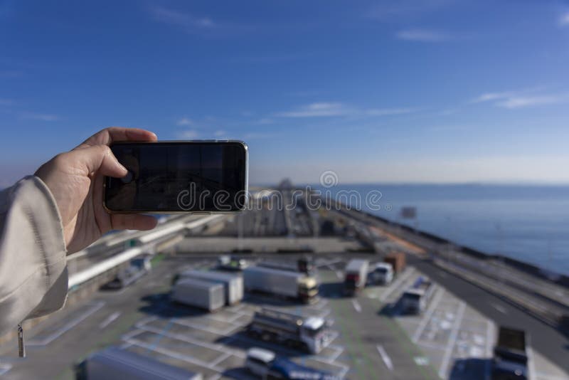 A traffic jam shooting by smartphone on the highway at Tokyo bay area in Chiba. High quality photo. Kisarazu district Chiba Japan 01.30.2024 Here is the highway parking called UMIHOTARU PA in Chiba. A traffic jam shooting by smartphone on the highway at Tokyo bay area in Chiba. High quality photo. Kisarazu district Chiba Japan 01.30.2024 Here is the highway parking called UMIHOTARU PA in Chiba