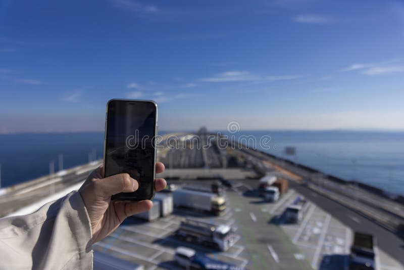 A traffic jam shooting by smartphone on the highway at Tokyo bay area in Chiba. High quality photo. Kisarazu district Chiba Japan 01.30.2024 Here is the highway parking called UMIHOTARU PA in Chiba. A traffic jam shooting by smartphone on the highway at Tokyo bay area in Chiba. High quality photo. Kisarazu district Chiba Japan 01.30.2024 Here is the highway parking called UMIHOTARU PA in Chiba