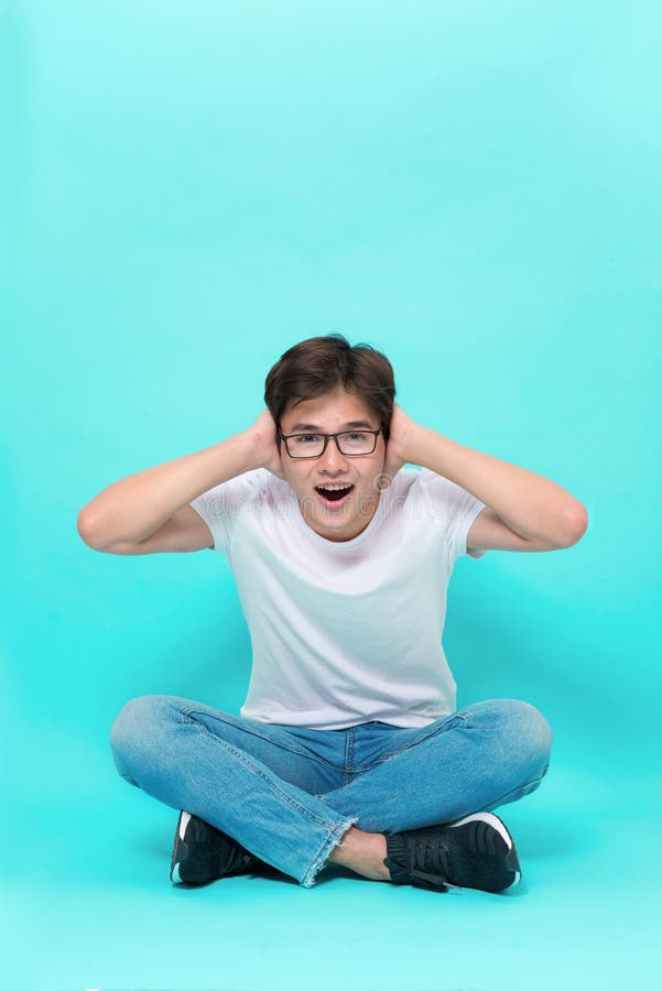 Eu estou t?o feliz voc? estou aqui Estúdio disparado do homem asiático brincalhão atrativo, sentando-se no assoalho com os pés cr fotografia de stock royalty free Eu estou t?o feliz voc? estou aqui Estúdio disparado do homem asiático brincalhão atrativo, sentando-se no assoalho com os pés cr fotografia de stock royalty free