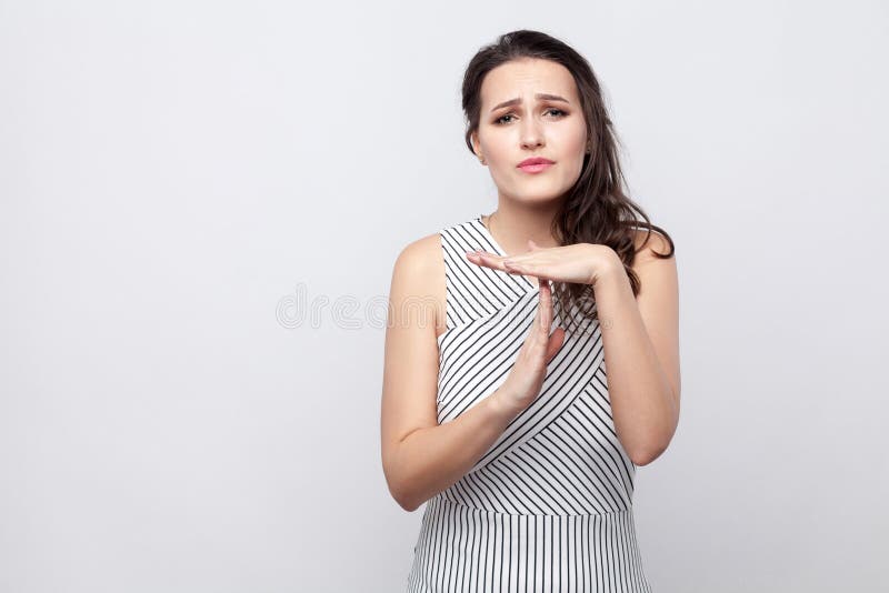 Eu preciso mais tempo Retrato da mulher moreno nova bonita esperançosa com composição e posição do vestido e intervalo listrados fotografia de stock royalty free Eu preciso mais tempo Retrato da mulher moreno nova bonita esperançosa com composição e posição do vestido e intervalo listrados fotografia de stock royalty free