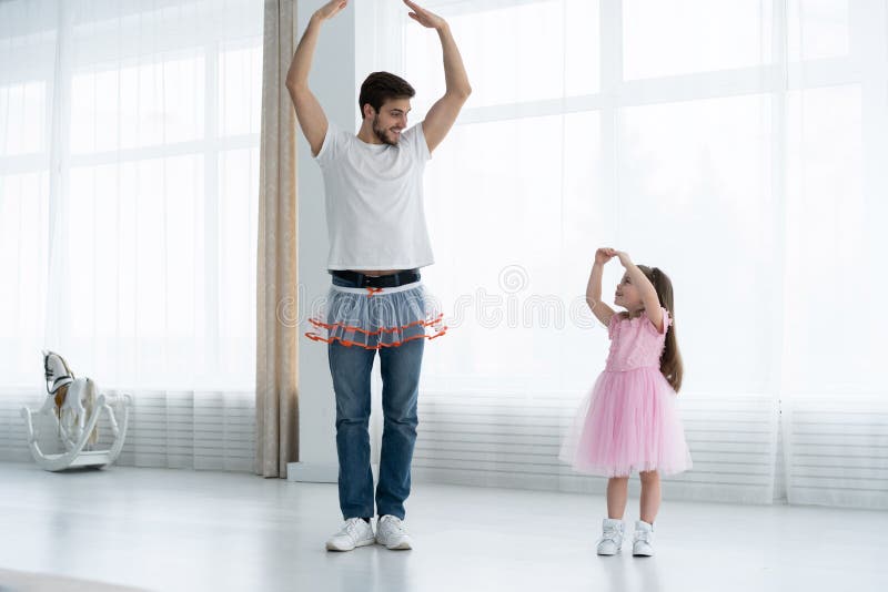 Eu te amo, paizinho! O homem novo considerável está dançando em casa com sua menina Dia feliz do ` s do pai! imagem de stock Eu te amo, paizinho! O homem novo considerável está dançando em casa com sua menina Dia feliz do ` s do pai! imagem de stock