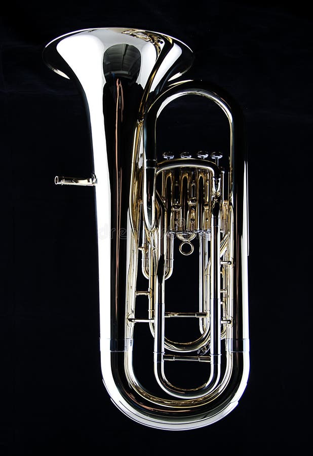 A complete brass gold bass tuba euphonium against a black background in the vertical format with copy space. A complete brass gold bass tuba euphonium against a black background in the vertical format with copy space.