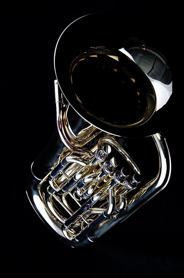 A complete brass gold bass tuba euphonium against a black background in the vertical format with copy space. A complete brass gold bass tuba euphonium against a black background in the vertical format with copy space.