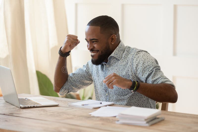 Euphoric young black man celebrating online lottery win.