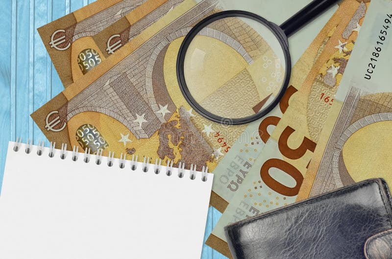 50 euro bills and magnifying glass with black purse and notepad. Concept of counterfeit money. Search for differences in details