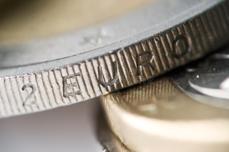 Extreme macro photo of a 2 Euro coin. The word '2 Euro' is visible. Very shallow depth of field. Gold in color with silver inset. NOTE: The extremely shallow depth of field was created by reversing a 50mm lens in front of a 100mm lens. The effect was achieved in camera, not during post processing.