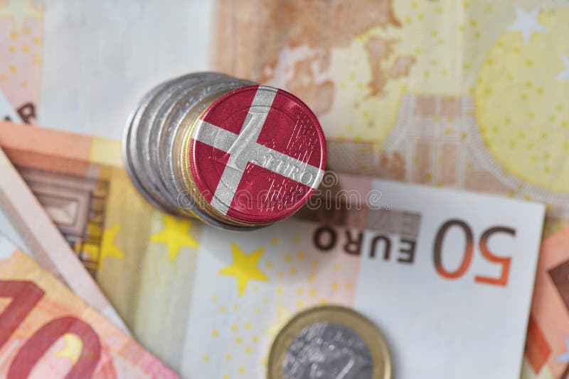 Euro coin with national flag of denmark on the euro money banknotes background.