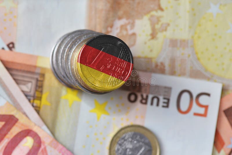 Euro coin with national flag of germany on the euro money banknotes background.