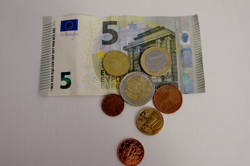 Euro fem och en encentmynt på en vit bakgrundsnärbild royaltyfri fotografi Euro fem och en encentmynt på en vit bakgrundsnärbild royaltyfri fotografi