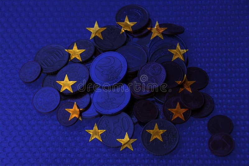 Euro metal coins on the background of the EU flag, the concept of financial development, devaluation, inflation, taxes