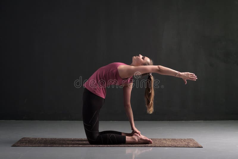 Woman yoga instructor doing advanced variation of camel pose or Ustrasana  asana Stock Photo by ©Koldunov 301727176