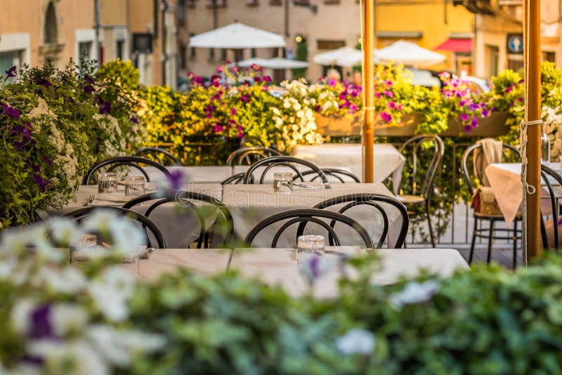 Europese straatrestaurant of koffie Lijsten met witte tafelkleden in openlucht royalty-vrije stock afbeeldingen Europese straatrestaurant of koffie Lijsten met witte tafelkleden in openlucht royalty-vrije stock afbeeldingen
