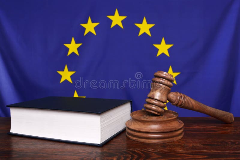 Still life photo of a gavel, block and law book on a judges bench with the European Union flag behind. Still life photo of a gavel, block and law book on a judges bench with the European Union flag behind.