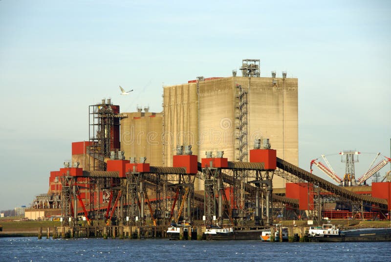Anchoraged sea-river barges in the harbour of Rotterdam, the netherlands, doing the coal and ironstone trans-shipment and at the background the processing factory. Barges rotterdam stock images, royalty-free photos and pictures