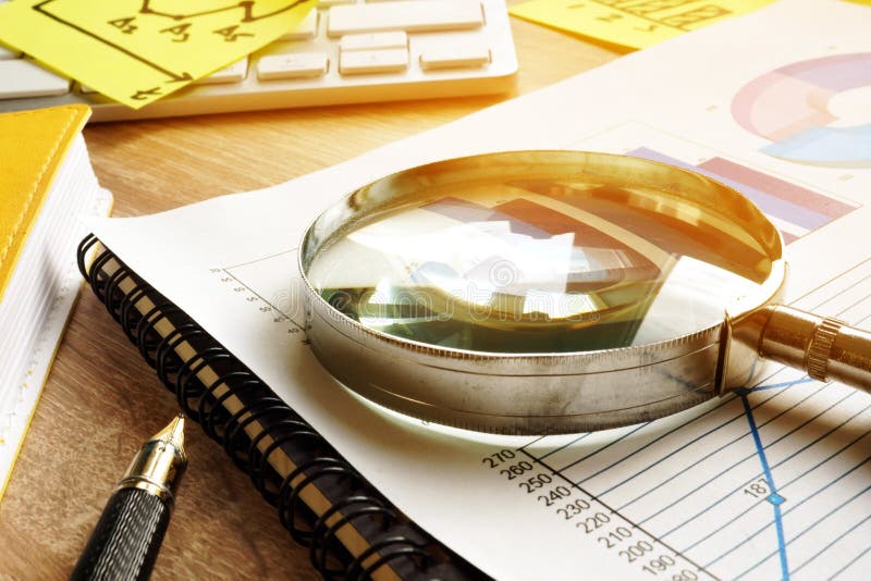 Business assessment and audit concept. Magnifying glass on a financial report. Business assessment and audit concept. Magnifying glass on a financial report.