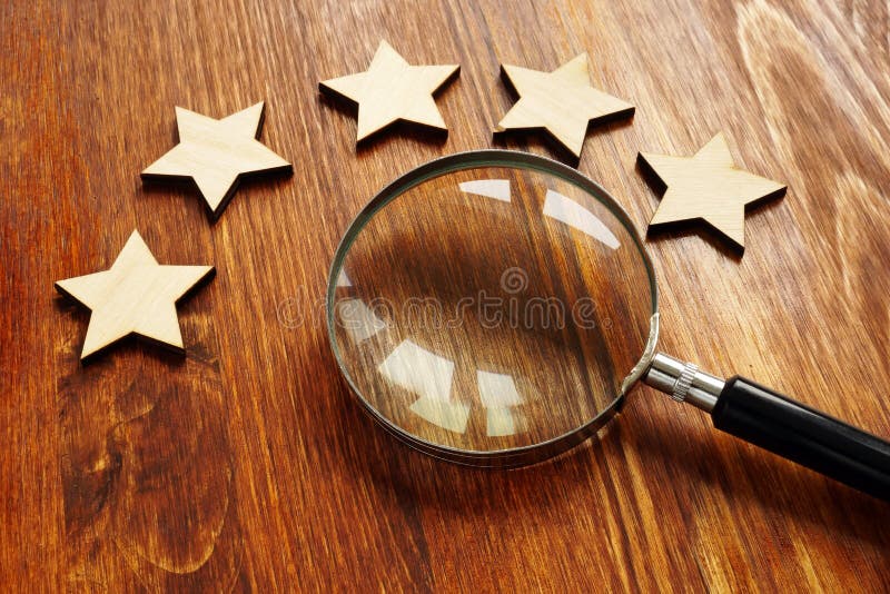 Evaluation and assessment concept. Five stars and magnifying glass