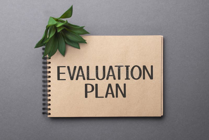 Evaluation plan text on craft colored notepad and green plant on the dark background royalty free stock photo