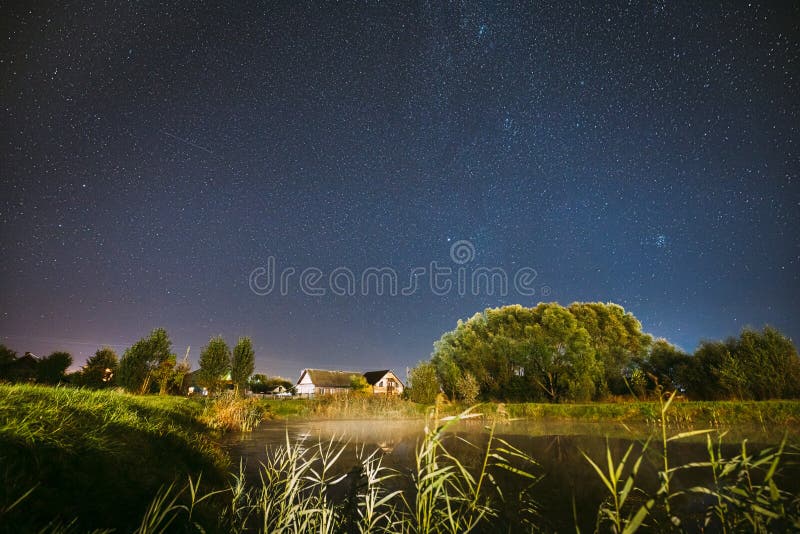 Evaporación Sobre El Lago Del Río Cerca De Las Casas En La Aldea Galaxia Vía Láctea En El Estelar De La Noche Sobre El Paisaje De fotografía de archivo Evaporación Sobre El Lago Del Río Cerca De Las Casas En La Aldea Galaxia Vía Láctea En El Estelar De La Noche Sobre El Paisaje De fotografía de archivo