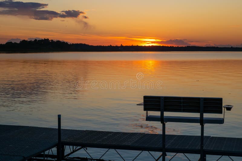 Evening scene at a Minnesota lake, with an emptly bench on a boat dock