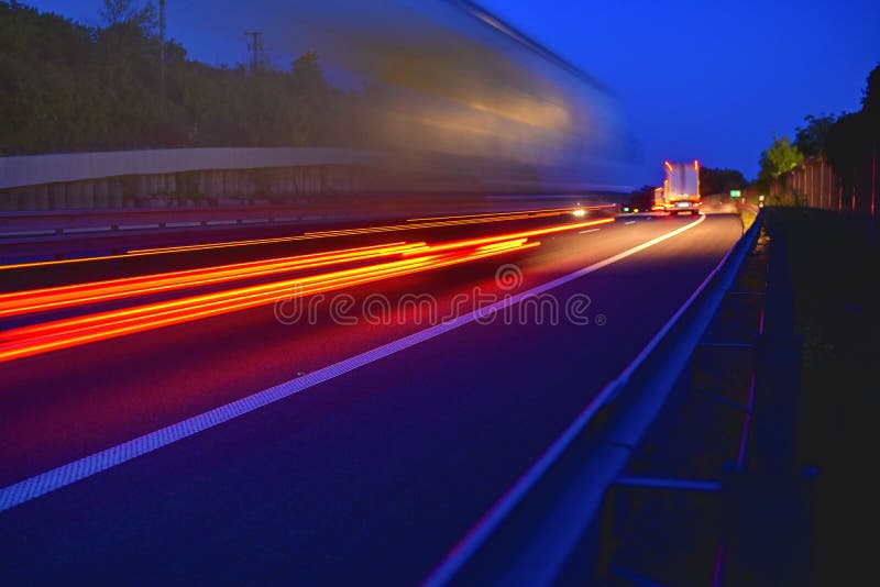 Evening shot of trucks doing transportation and logistics on a highway. Highway traffic - motion blurred truck on a