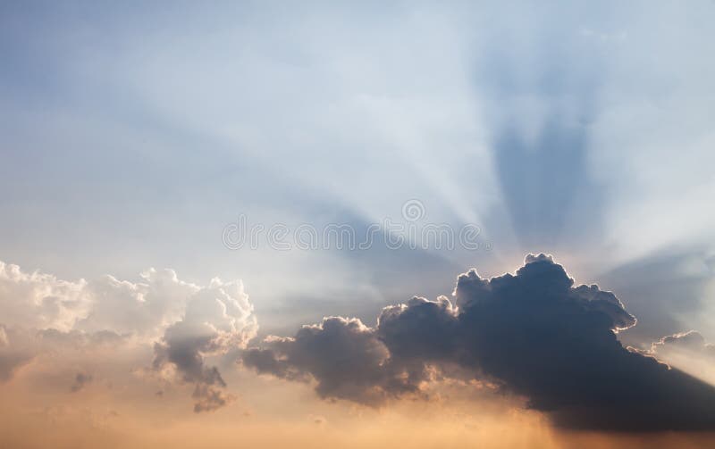 The evening sky is have a beam of light passing through the layers of clouds stock photos