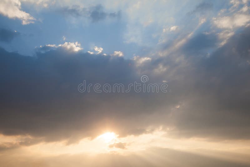 The evening sky is have a beam of light passing through the layers of clouds stock image
