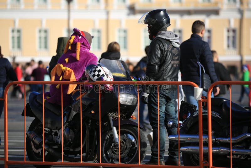 Bikers and a motorcycle stand near the orange fence royalty free stock images Bikers and a motorcycle stand near the orange fence royalty free stock images