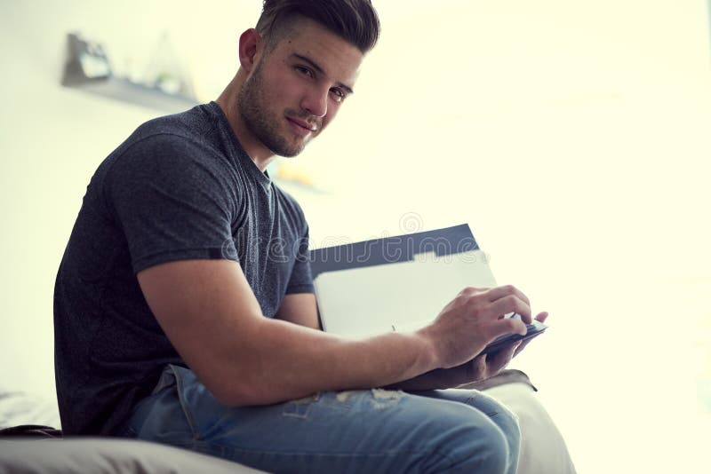 Every accomplishment starts with the decision to try. Portrait of a confident young man studying some paperwork while stock photo
