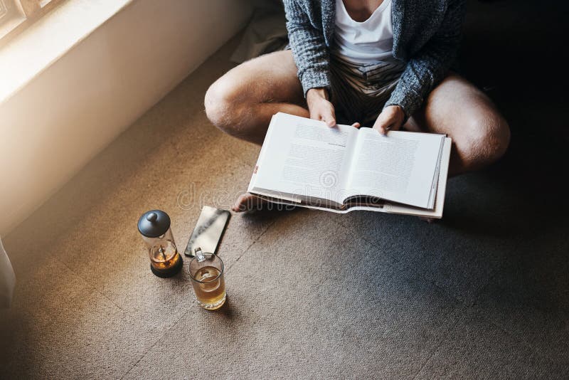 Every man needs to spend time learning and acquiring knowledge. High angle shot of an unrecognizable man reading a book stock photos