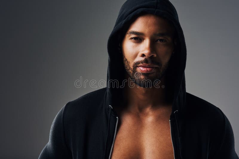 Every woman needs a man like me. Portrait of a handsome young man wearing a hoodie posing against a grey background.