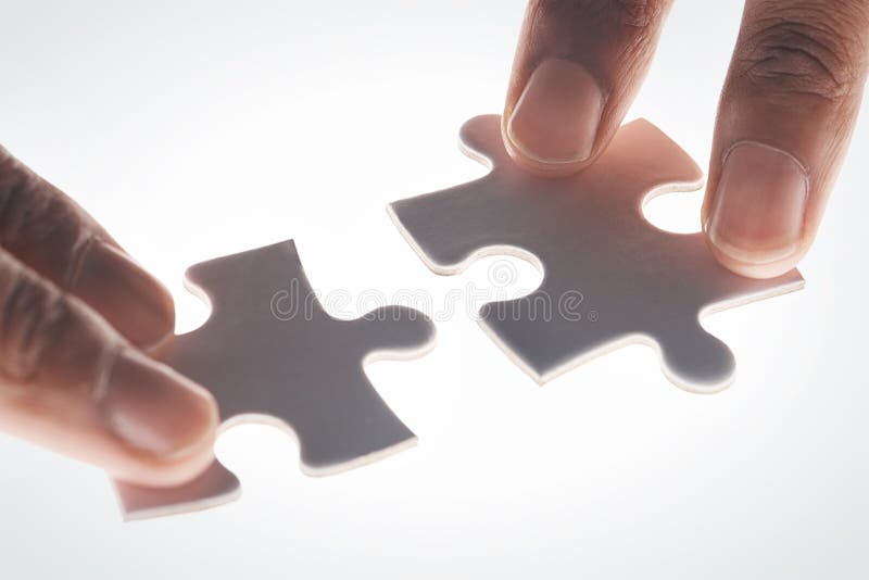 Everything is Falling into Place. Hands Holding Two Puzzle Pieces