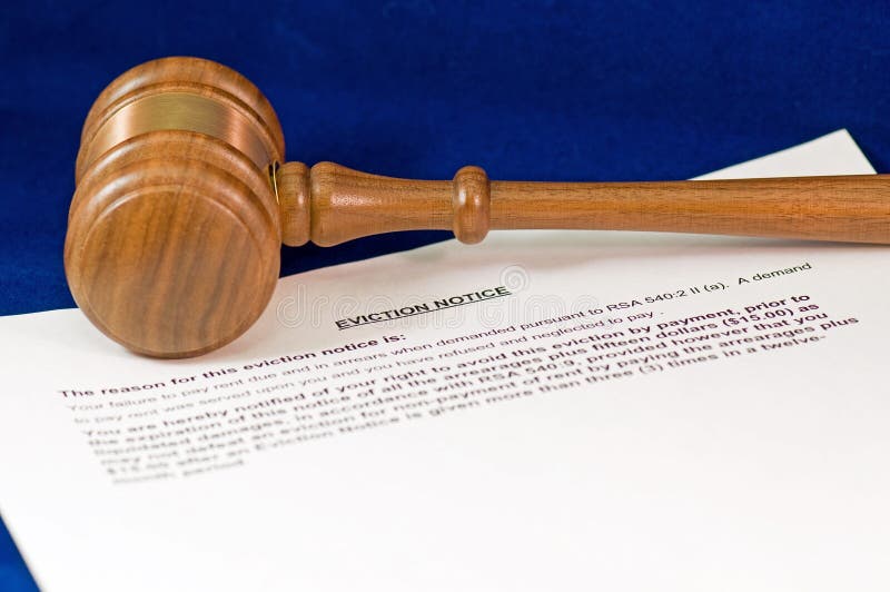 A closeup detail of a legal notice of eviction and a wooden judge's gavel. A closeup detail of a legal notice of eviction and a wooden judge's gavel.