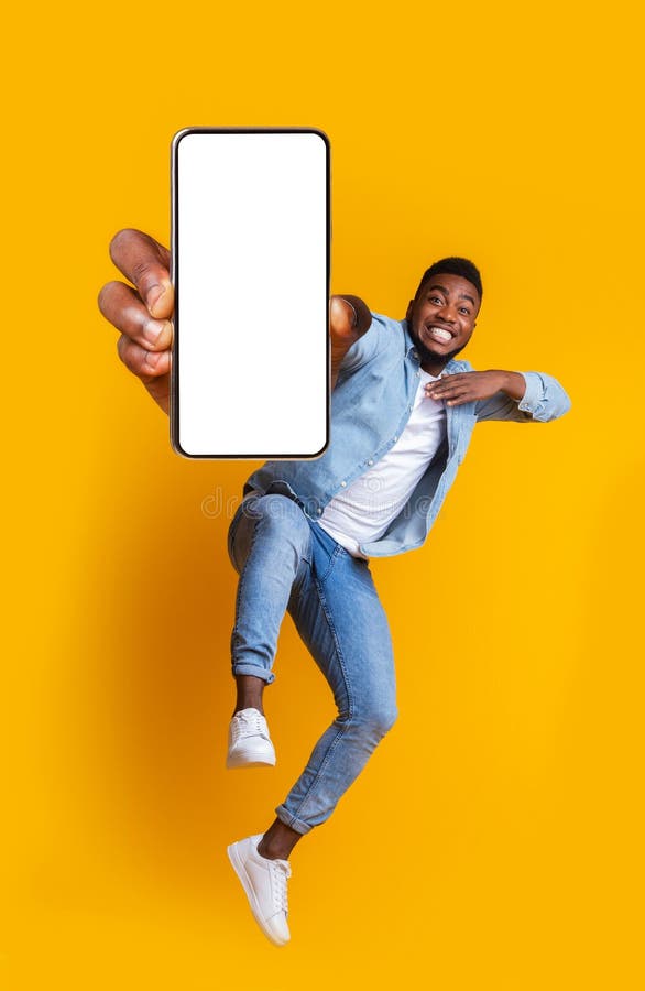 Exaltado hombre africano bailando con smartphone moderno