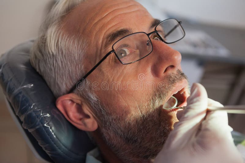 Dentist examining a patients teeth in the dentists chair at the dental clinic. Dentist examining a patients teeth in the dentists chair at the dental clinic