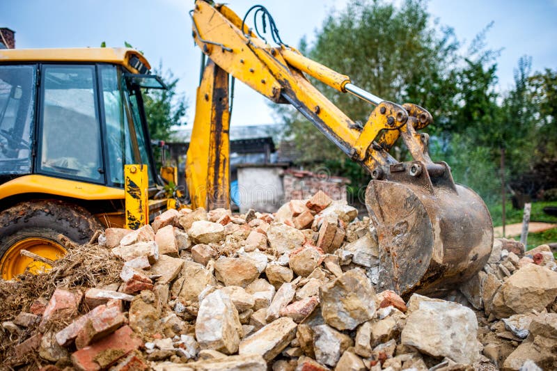 Excavador En El Sitio De Demolición Que Carga Los Bloques De Cemento