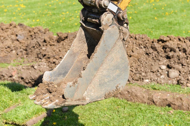 Excavator Arm Digging Deep, Works on a Construction Site Stock Photo