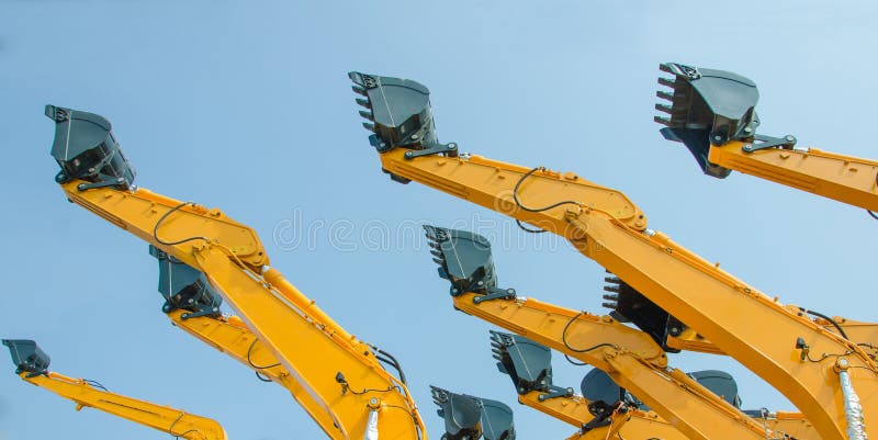Excavator bucket on the end of a yellow hydraulic arm of a digging machine. Track hoe construction excavator stock images, royalty-free photos and pictures