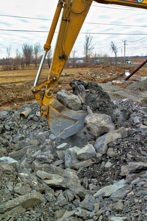 Excavator bucket digging rocks