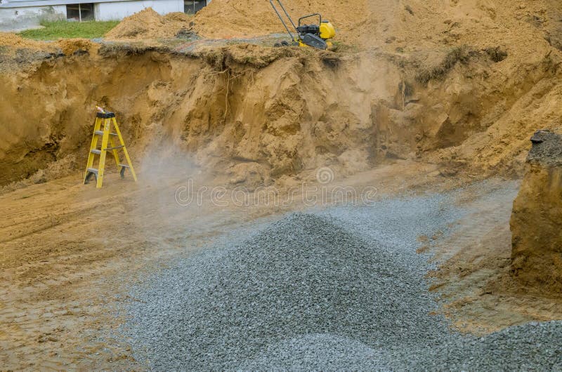 Excavator With A Bucket Lowered Down Gravel Stones For Construction Of