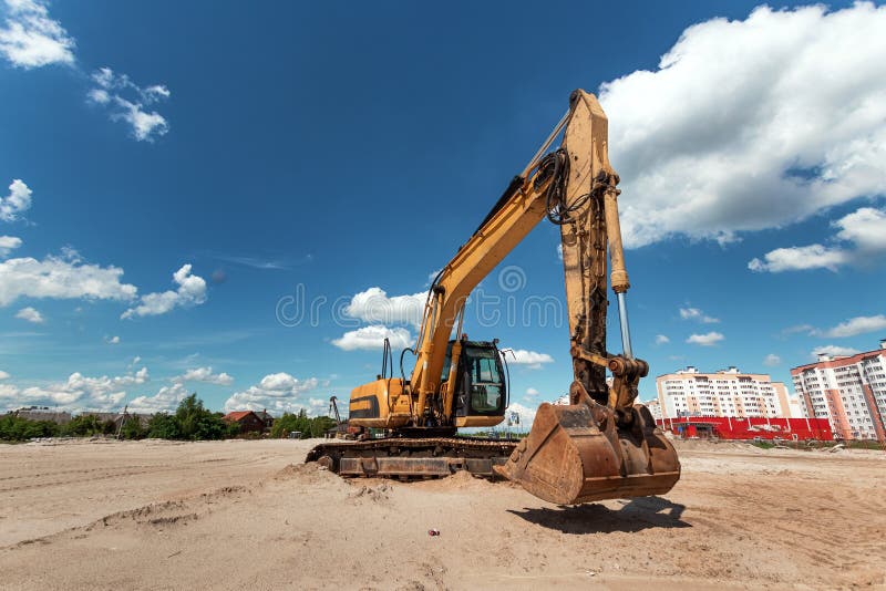 Excavator on a construction site against a blue sky. Construction, technology, architecture.
