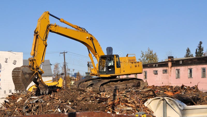 Excavator demolishes old buildings in preparation for new road and bridge. Track hoe construction excavator stock images, royalty-free photos and pictures