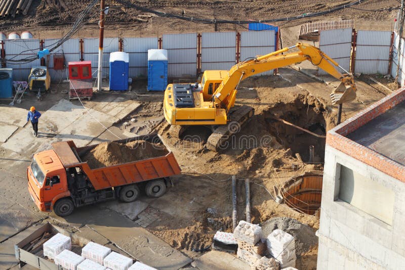 Excavator digs hole at construction site. royalty free stock photo