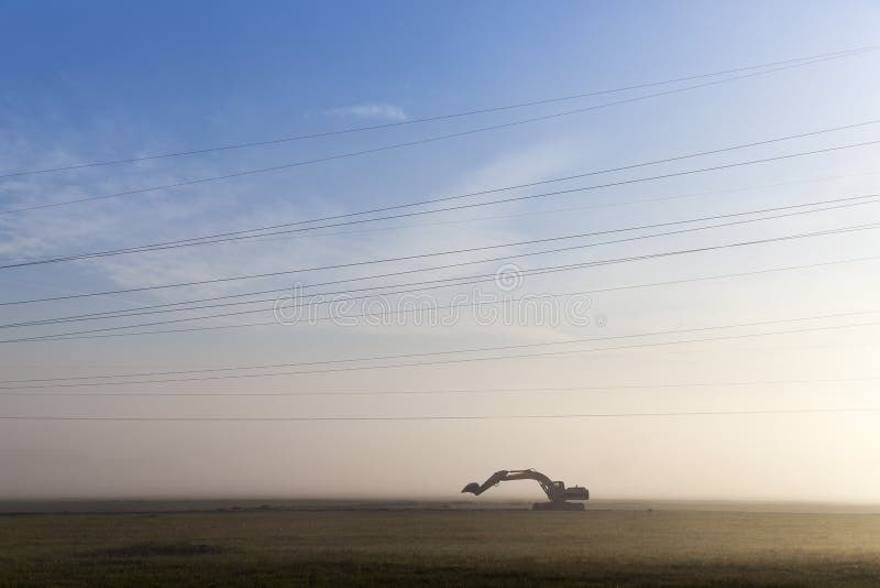 Excavator in a fog royalty free stock image